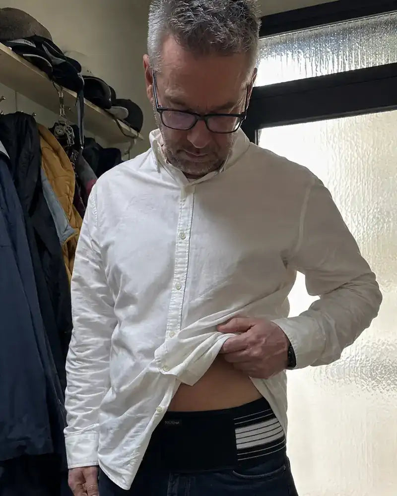 Tomáš ukazuje bederní pás pod košilí